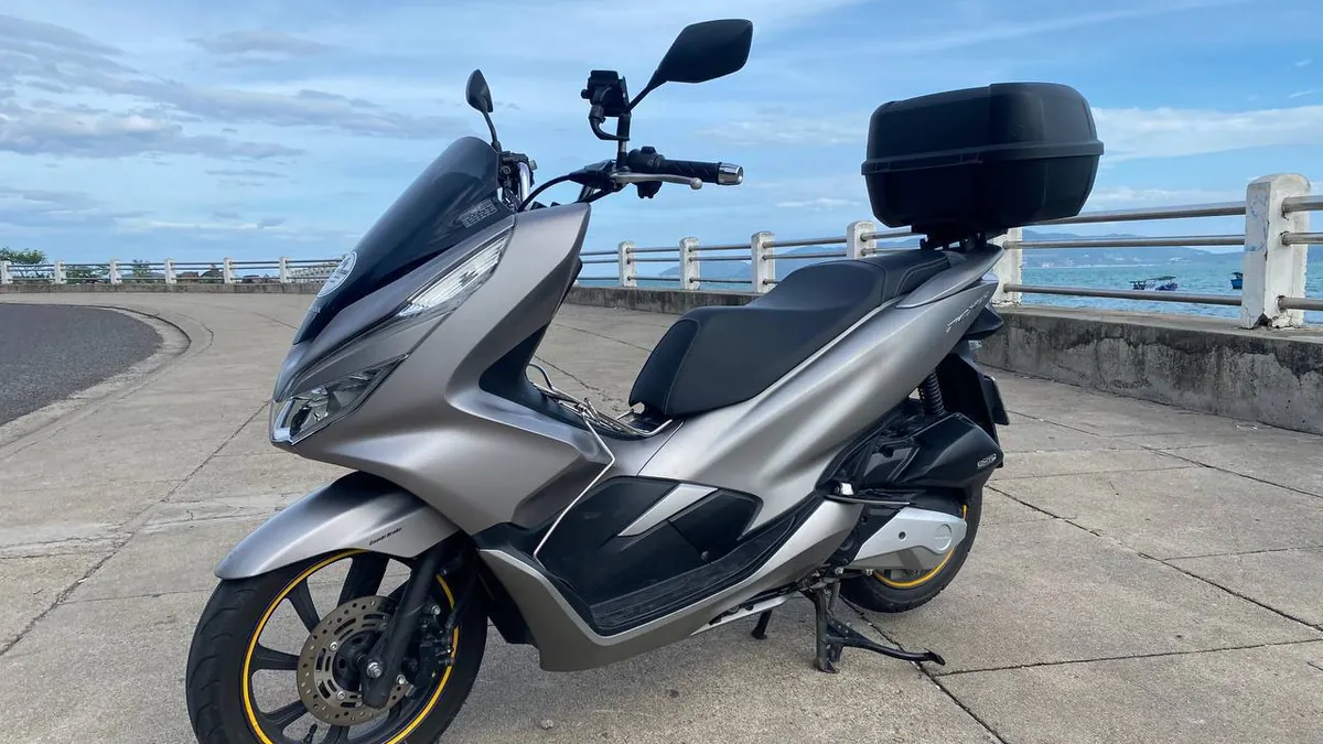 Арендованный скутер Honda PCX с кофром на набережной Нячанга у моря