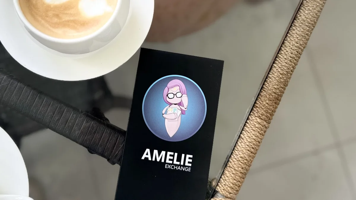 Визитка Амели (Amelie Exchange) и чашка кофе на столике в кафе Нячанга